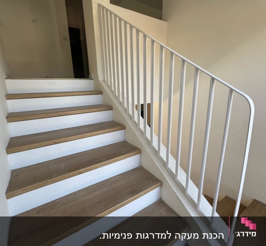 מדרגות עץ עם מעקה מתכת לבן